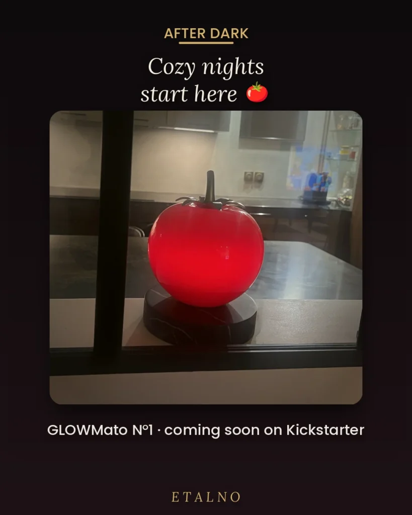 Glowing red tomato-shaped lamp on a black circular base